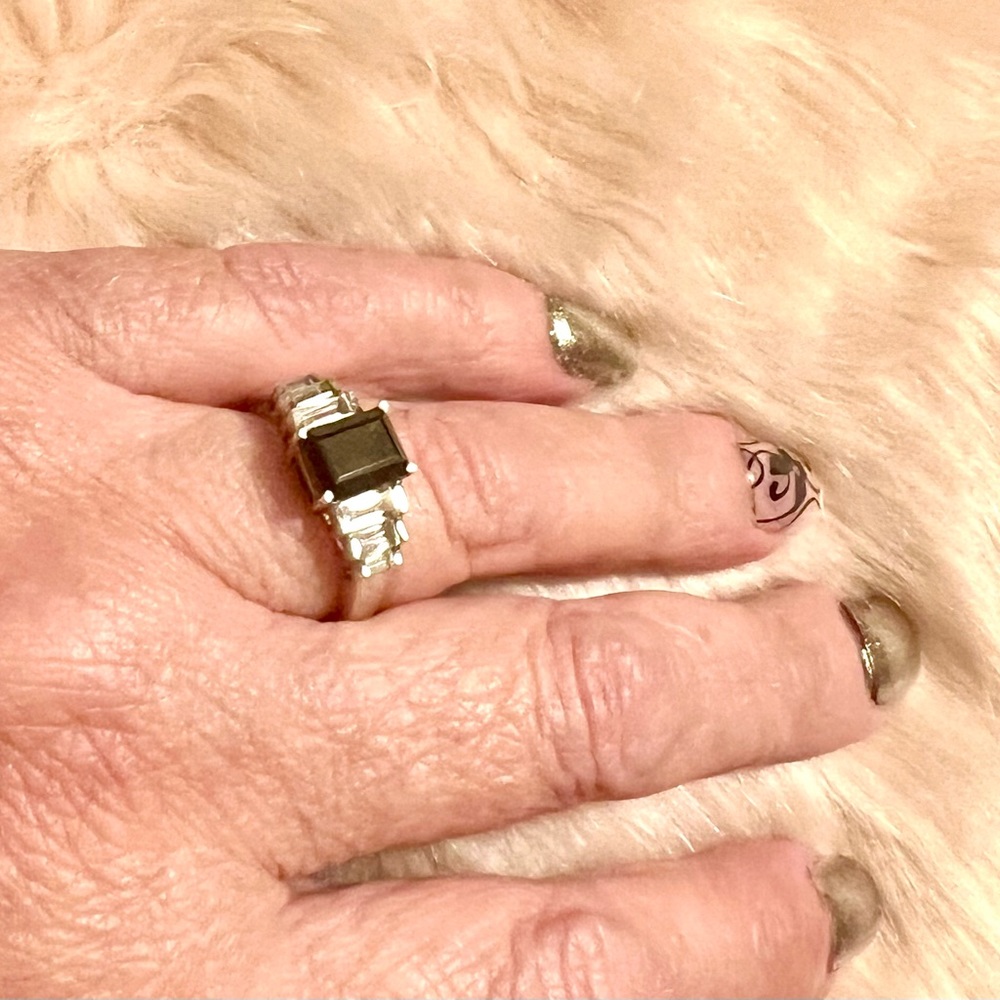 Black spinel emerald cut ring with white topaz baguettes on side.